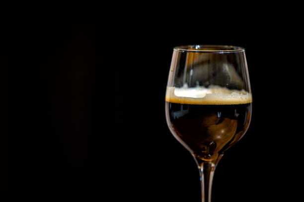 istock Dark beer in a glass on a black background. 1453552060