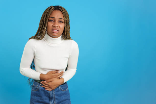 istock African woman touching her belly gesturing stomachache 1453557801