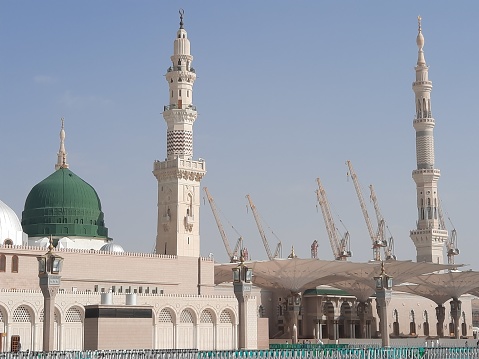 Beautiful daytime view of Masjid Al Nabawi, Medina's green dome, minarets and mosque courtyard.