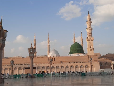 Beautiful daytime view of Masjid Al Nabawi, Medina's green dome, minarets and mosque courtyard.