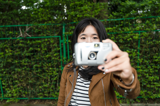 A happy Chinese girl who took photos with a film camera