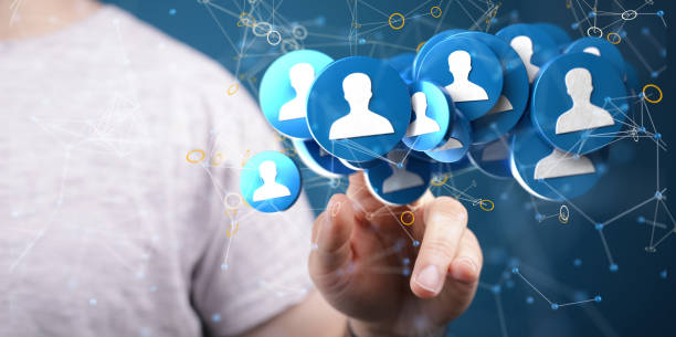 istock Hand touching 3D rendered human icons on a blue background for a global networking concept 1453565241
