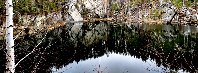panoramic view of a flooded quarry in the forest called Talc stone near Yekaterinburg at the beginning of winter, previously the mineral talc was mined here