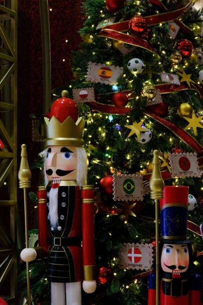 istock Vertical shot of the Nutcracker character in front of a Christmas tree with national flags 1453571187
