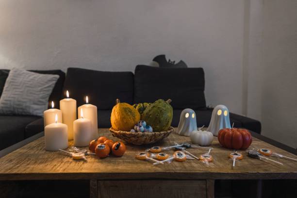 istock Halloween decorations of cups, candles, ghost figures, and pumpkins put on the table 1453576938