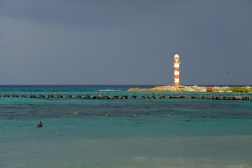 A landscape of the Cancun Lighthouse surrounded by the sea in the evening in Mexico