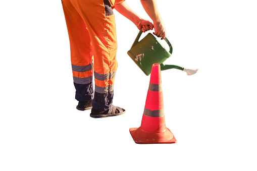 A road worker draws a stop line on the asphalt with white paint using a watering can, isolated on a white background