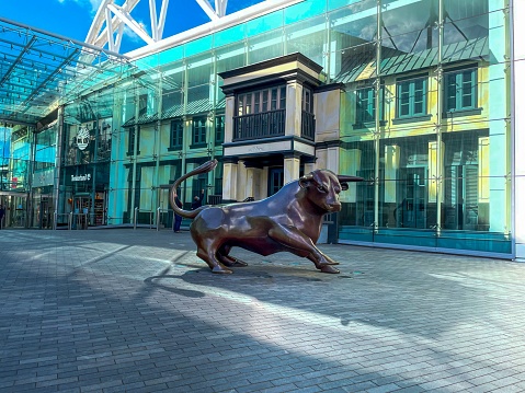 Birmingham, United Kingdom – April 06, 2021: The Bull statue in front of a glass building. Bullring & Grand Central, Birmingham, England.