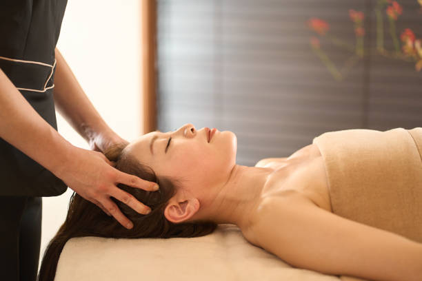 kobieta otrzymująca masaż głowy w salonie piękności - head massage headache massaging alternative therapy zdjęcia i obrazy z banku zdjęć