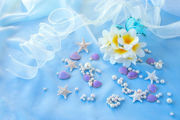 白いプルメリアと白い紫色の貝殻と真珠とリボン - pearl shell starfish beach ストックフォトと画像
