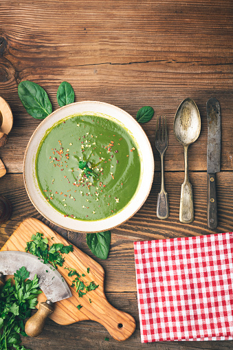 Table top with green veggie soup with copy space