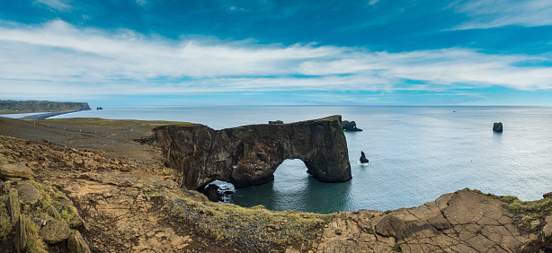 Picturesque autumn evening view to Dyrholaey coast cliffs and rocky arch, Vik, South Iceland. Reynisfjara ocean  black volcanic sand beach in far.