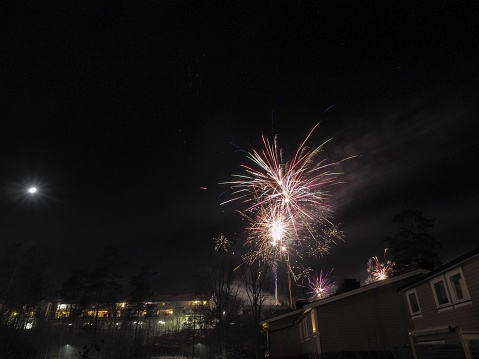 Fireworks on new year's eve, above roof tops in a small village in Norway