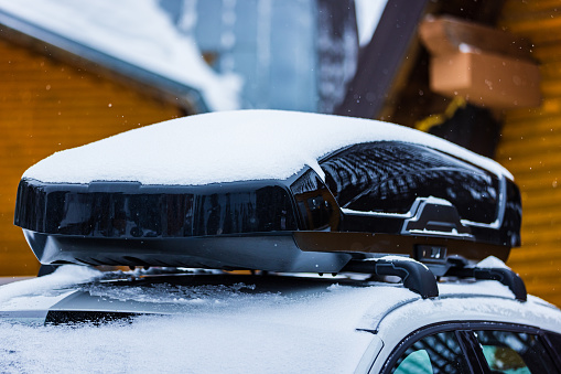 Roof rack with cargo box on car roof in winter.