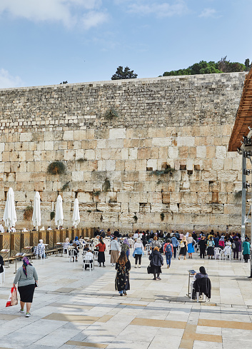 The Wailing Wall, Jerusalem, Israel - November 11, 2021: Jewish orthodox believer reading the Torah and praying facing the Western Wall, also known as Wailing Wall in the old city in Jerusalem, Israel.