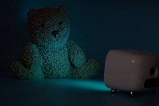 Stuffed Teddy Bear watches TV in the Dark