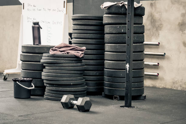 pila de pesas en el piso de un gimnasio - foto de stock