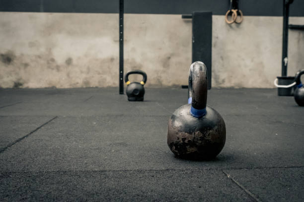 kettle bells e dumbells em um chão - foto de acervo