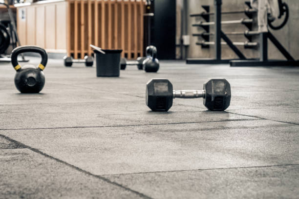 kettle bells e dumbells em um chão - foto de acervo