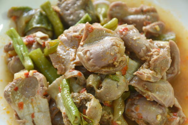 spicy stir-fried chicken gizzard couple liver with yard long bean and chili stock photo