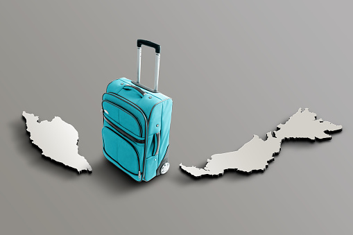 Blue suitcase on blank 3d map of Malaysia. Copy space. No people. Horizontal orientation.