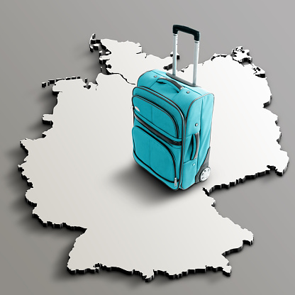Blue suitcase on blank 3d map of Germany. Copy space. No people. Horizontal orientation.