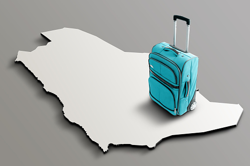 Blue suitcase on blank 3d map of Saudi Arabia. Copy space. No people. Horizontal orientation.