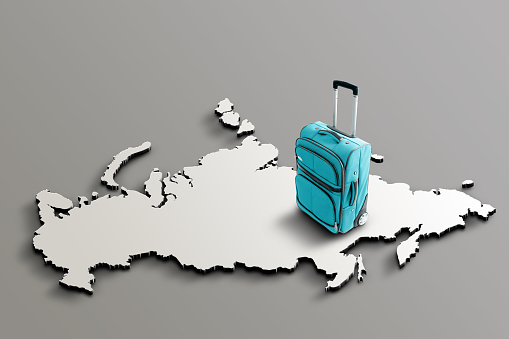 Blue suitcase on blank 3d map of Russia. Copy space. No people. Horizontal orientation.