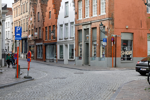 Bruges, Belgium - September 13, 2022: Brick buildings located in narrow cobbled streets in the old part of the city. There are houses with visible stepped gables