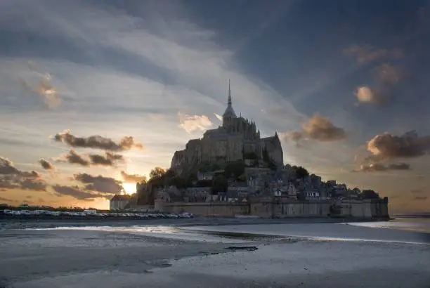 A beautiful view of Mont-St-Michel tidal island against cloudy sky at sunrise in Normandy, France