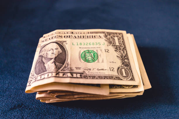istock United States one dollar bills on a blue sofa. 1453606789