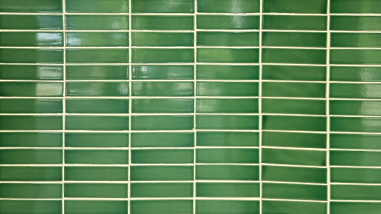 close up green mosaic wall tiles in tropical istyle. real antique ceramic interior wall tiles. wall tiles background for modern, simple, bold, fresh, soft, earth tone concept.