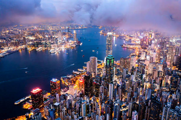 paisaje urbano aéreo de hong kong por la noche. rascacielos de la ciudad y puerto con luces encendidas - hong kong asia skyline night fotografías e imágenes de stock