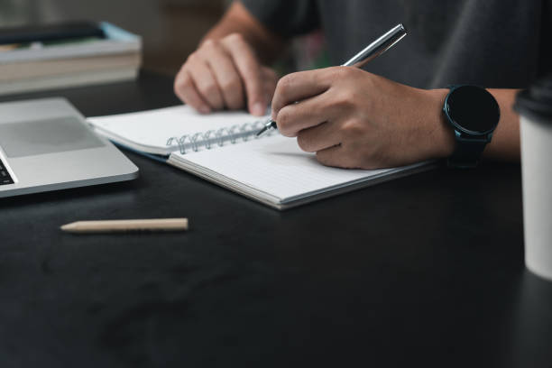 istock man hands with pen writing on notebook in the office.learning, education and work.writes goals, plans, make to do and wish list on desk. 1453608768