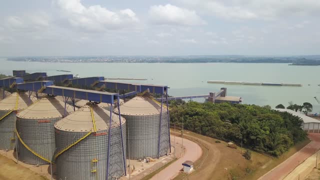 Silos to store soybeans in Brazil and to transfer them to waterway barges on a mechanical conveyor - aerial view