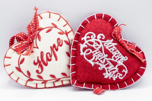 A small red fabric heart rests on top of a home sweet home sampler.