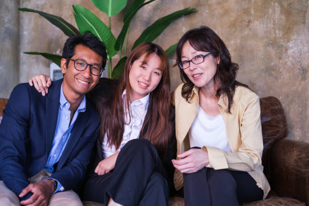 Group of business people relaxing in the rest area of the office and having a fun time Group of business people relaxing in the rest area of the office and having a fun time pacific islander ethnicity stock pictures, royalty-free photos & images