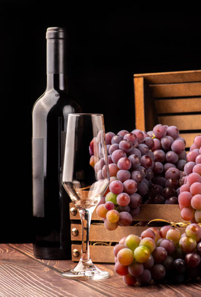 istock Grapes, details of beautiful grapes and wine on rustic wooden table, selective focus. 1453610988