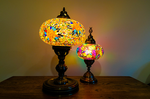 Illuminated Turkish Moroccan handmade stain glass lamps. Vibrant and colourful giving home décor a cosy feel. Copy space, blurred background, home style concept. Awesome traditional background.