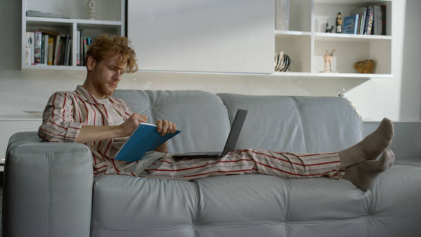 istock Manager working making notes in pajamas at remote office. Student watch seminar 1453613435