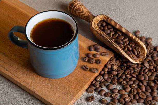 istock Blue cup of coffee with coffee beans on wooden background 1453614202