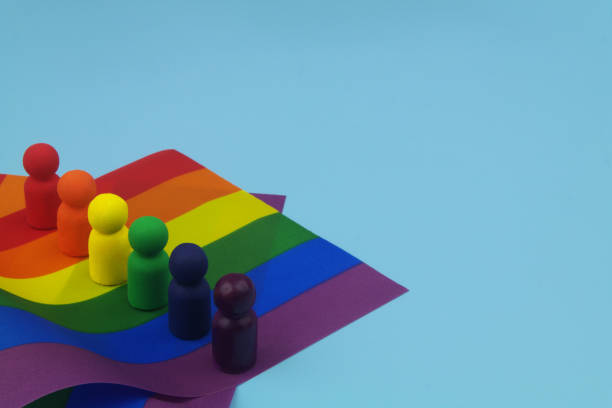 istock Rainbow colored people figures on LGBT pride flag on blue with copy space. 1453614251