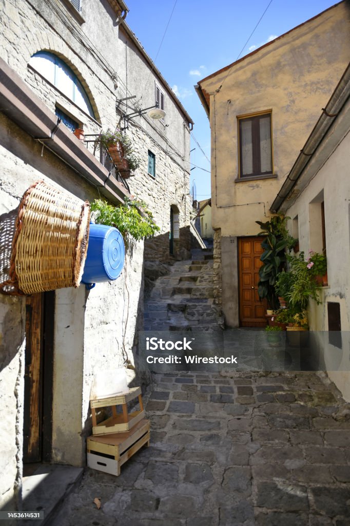 Narrow old street paved with stone. Stairs leading up.Architecture of the old style. A narrow old street paved with stone. Stairs leading up, Castelmezzano is a village in the Basilicata region of Italy. Alley Stock Photo