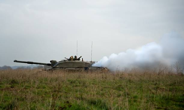 istock Military tanks moving in a field 1453615460
