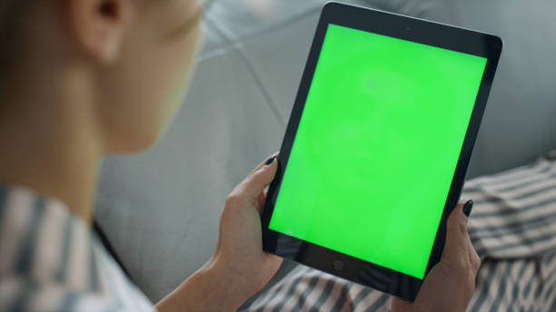 istock Woman holding mockup tablet computer at home closeup. Student watching online 1453615578