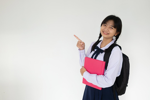 Young student girl hold pink book on white background.
