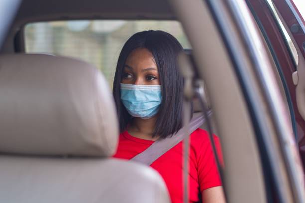 istock lady with a face mask commuting in a taxi 1453628395