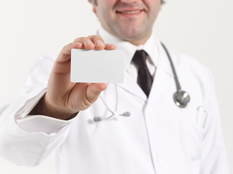 Happy smiling doctor showing business card
