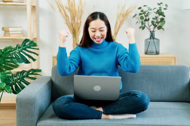 istock Happy woman with laptop celebrating victory 1453632065