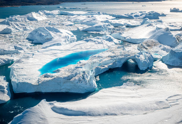 piscina azul e arco do túnel nos icebergs no oceano ártico na groenlândia - rugged coastline - fotografias e filmes do acervo